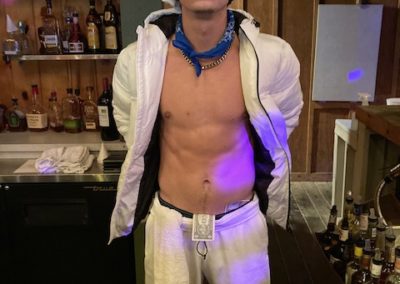 Peson wearing white chefs hat and white outfit stands in bar area for Dunes Resorts Halloween 2021 Party.