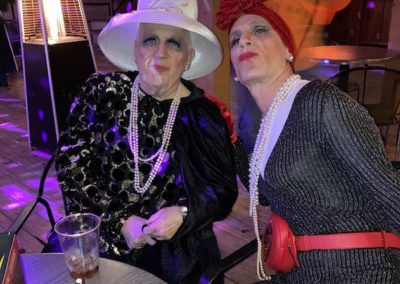 Two people dressed up and wearing pearls as costumes for Dunes Resorts Halloween 2021 Party.