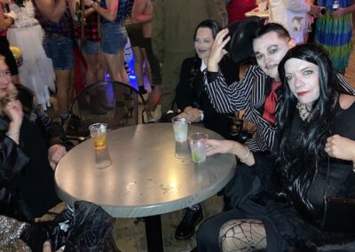 Group of individuals dressed in Adams family costumes for Dunes Resorts Halloween 2021 Party