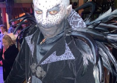 Person wearing dark feathered costume poses for Dunes Resorts Halloween 2021 party.