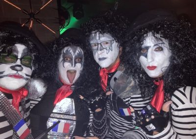 Four people dressed in black and white rocker costumes pose for Dunes Resorts Halloween 2021 party.