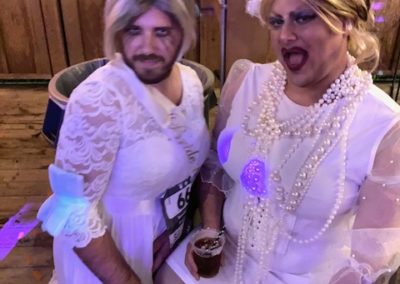 Two people dressed in all white costumes look into the camera while posing for picture at Dunes Resorts Halloween 2021 Party.