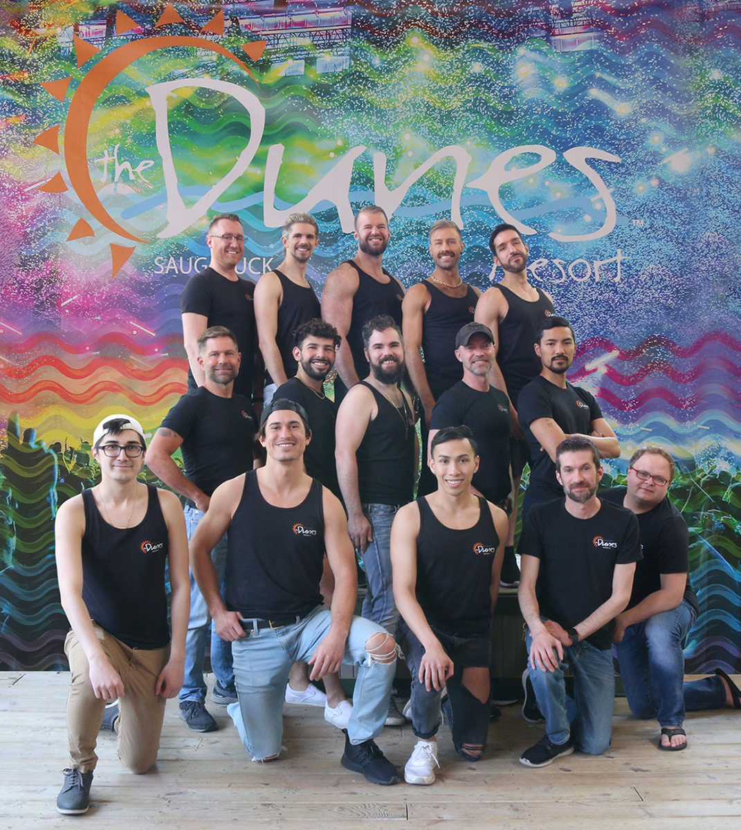 The Dunes Resort of Saugatuck employees pose in front of company sign as a team.
