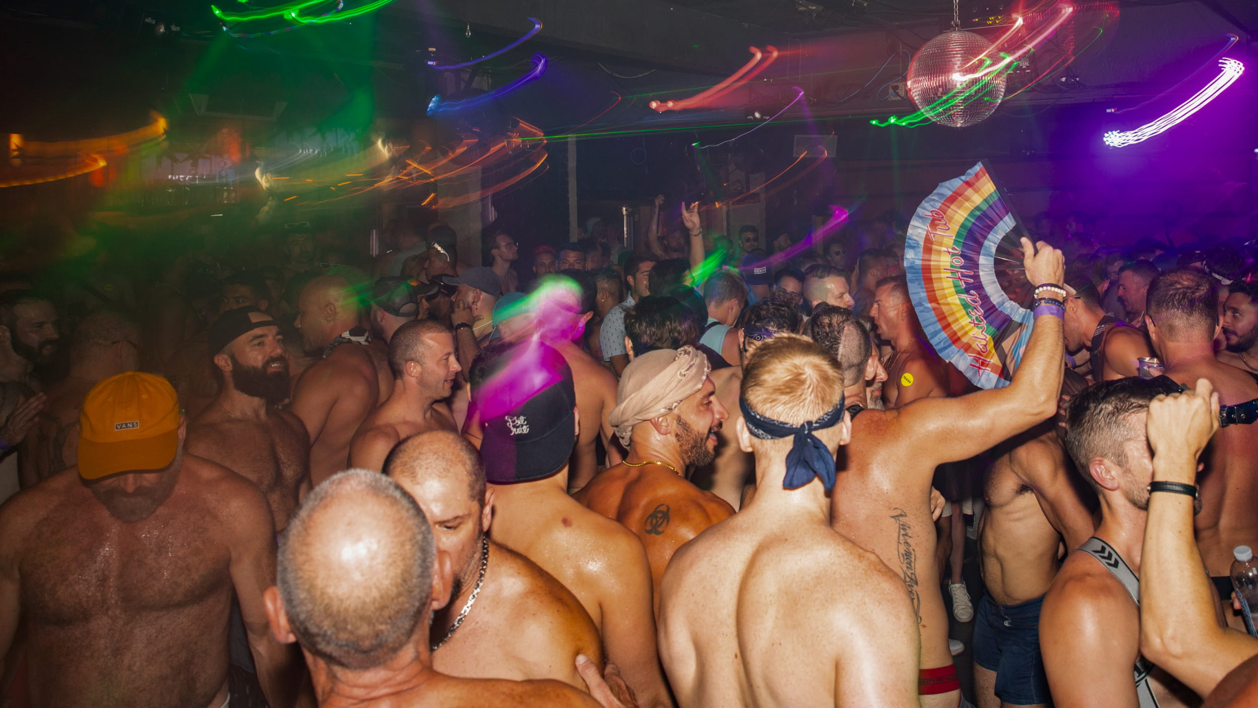 Crowded dance floor with vibrant lights at the Nightclub, people enjoying a lively night out.